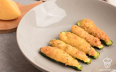 Готовые кабачки с сыром и яйцом выложите на тарелку и подавайте к столу в горячем виде.