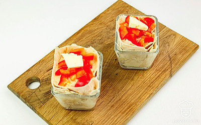 Сверху на курицу выложите кусочки болгарского перца и сливочное масло. Отправьте курицу запекаться в духовку на 40-50 минут.