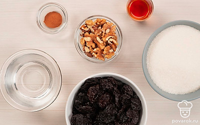 Чернослив хорошо промойте, удалите все косточки, разрезая каждую ягоду пополам. Подготовьте посуду для варки варенья с толстым дном и стенками. Простерилизуйте посуду для хранения варенья. Заварите зеленый чай. Засыпьте половинки плодов чернослива двумя стаканами сахара и оставьте на 1 час. Грецкие орехи мелко порубите и залейте водой, оставьте на 1 час, после слейте воду. Совет: небольшие банки удобно стерилизовать в духовке или микроволновке.