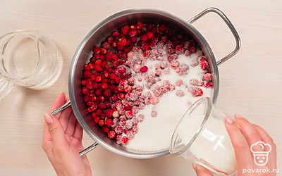 Начните варить варенье. Ягоды переложите в кастрюлю. Насыпьте сахар и налейте воду. Поставьте кастрюлю на средний огонь. Доведите до кипения, уберите огонь до минимума. Варите варенье 5 минут, постоянно помешивая ложкой. Выключите огонь, дайте варенью остыть.