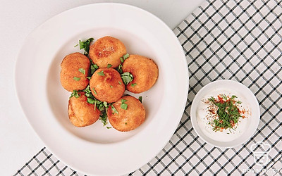 Шарики готовы. Подайте их на сервировочном блюде с соусом, украсьте мелко нарубленной свежей зеленью.