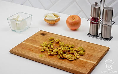 Оливки также порежьте пополам.