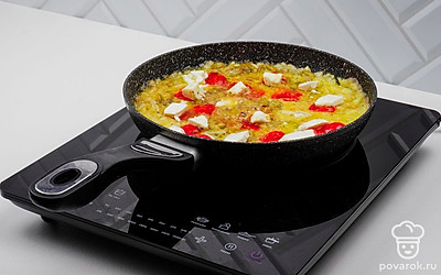 Вылейте в сковороду взбитые яйца и выложите равномерно кусочки феты.