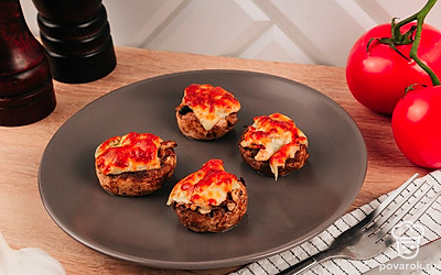 Горячие фаршированные грибы легко заменят полноценный обед или ужин, в холодном виде такие грибы можно подать на листьях салата.