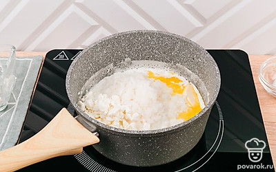 В сотейнике разогрейте молоко, сливочное масло, почти готовый рис и творог. Варите на медленном огне до полной готовности риса.