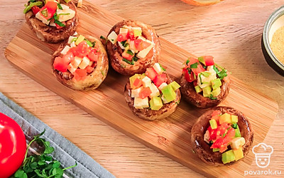 Достаньте запеченные шляпки шампиньонов из духовки и начините гуакамоле с сыром.