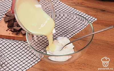 Приготовьте крем из сметаны и сгущенки. Для этого возьмите глубокую миску и выложите в нее сметану и только часть сгущенного молока. Начинайте взбивать на средней скорости, пока ингредиенты не смешаются. Продолжайте добавлять сгущенку в смесь, пока не останется 1/3 части.
