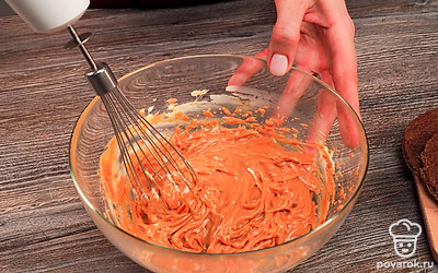 Начните готовить крем для профитролей со сгущенкой и маслом. Возьмите глубокую миску и положите в нее масло. Добавьте к маслу вареную сгущенку. Включите миксер и взбивайте массу 3-4 минуты, пока она не станет однородной.