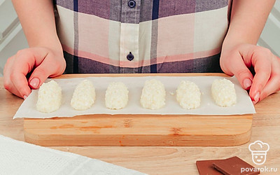 Сформируйте небольшие колбаски-батончики. Масса должна держать форму. Если этого не происходит, добавьте немного сгущенки. Сформированные батончики выложите на пергамент или бумагу для выпечки и отправьте в морозилку на 20-30 минут.