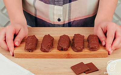 Выложите шоколадные батончики на чистую бумагу для выпечки, оставляя расстояние между ними. Когда все будут готовы, поместите «Баунти» в холодильник на 2 часа, чтобы шоколад застыл.