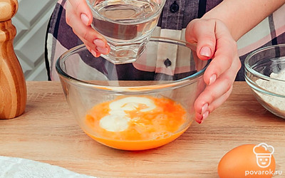 Затем добавьте к майонезу и яйцу воду, продолжая энергично взбивать смесь.