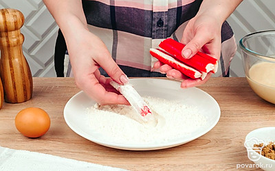 Обваляйте каждую крабовую палочку в муке.