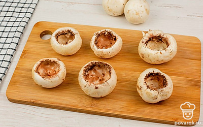 Аккуратно удалите ножки шампиньонов, не задевая шляпки. Твердый сыр натрите на крупной терке. Измельчите чеснок или воспользуйтесь чеснокодавилкой.