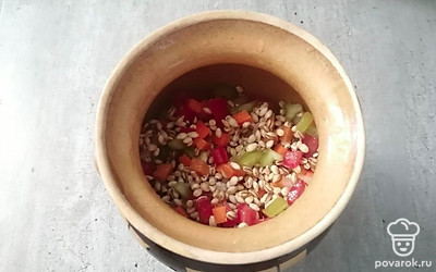 Выложите перловую крупу с овощами в горшочек.