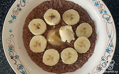 Выложить хлопья на тарелку, сверху выложить бананы, добавить мед и кусочек сливочного масла. Блюдо готово.