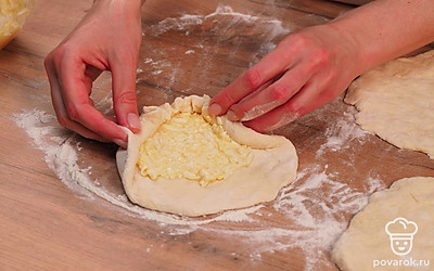 В центр каждой лепешки положите начинку, разделив ее на 3 равные части. Заверните начинку в тесто, собрав его к верхушке. Уплотните руками, переверните и слегка разомните. Аккуратно раскатайте скалкой. Проткните вилкой в нескольких местах, чтобы при выпечке выходил воздух.