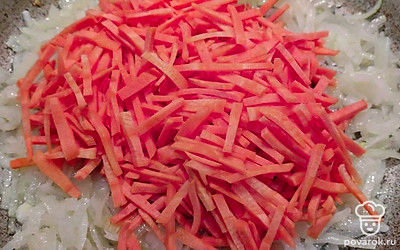 Нарезанный лук обжарьте на растительном масле 2 минуты. Добавьте измельченную морковь. Жарьте 3 минуты. 