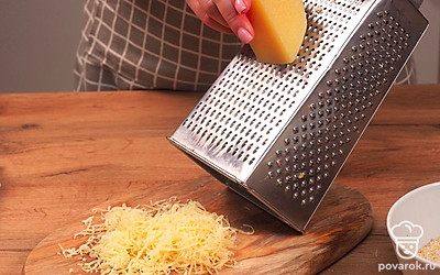 Приступите к подготовке основы сырных палочек. Два видв сыра натрите на мелкой терке и перемешайте. В емкость небольшого размера разбейте яйцо и взбейте его. Панировочные сухари насыпьте в глубокую тарелку. Лаваш нарежьте на небольшие кусочки.