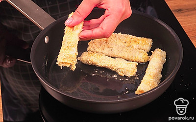 Приступите к приготовлению. На край лаваша выложите сырную начинку, сверните рулетиком. Обмакните в яйцо, обваляйте в сухарях. На сковороде с добавлением масла обжарьте палочки до румяности с двух сторон, ориентировочно по 2-3 минуты с каждой.