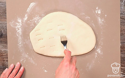 Подготовьте хачапури к обжарке. Разделите тесто на равные части. Каждую часть раскатайте скалкой на круглые лепешки толщиной около 0,5 см. В центр каждой положите начинку. Заверните начинку в тесто, собрав его к верхушке. Уплотните руками, переверните и слегка разомните. Аккуратно раскатайте скалкой. Проткните вилкой в нескольких местах, чтобы при выпечке выходил воздух.