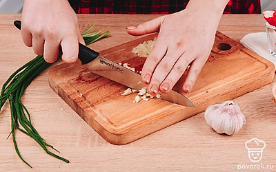 Зубчик чеснока раздавите плоской стороной ножа, а после нарежьте мелким кубиком и отправьте в миску к луку.