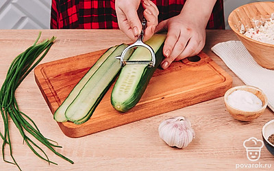 Огурец нарежьте на тонкие длинные пластины с помощью овощечистки.