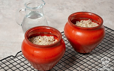 Выключите духовку. Перемешайте кашу и влейте немного кипятка. Поставьте горшочки в выключенную духовку и оставьте еще на 15 минут.