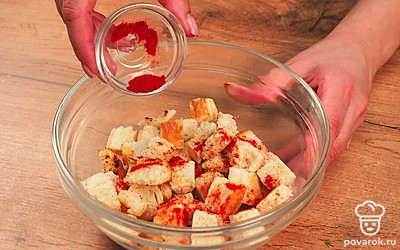 Обжарьте сухари на сковороде. Раскалите сковороду на сильном огне. Налейте в нее немного масла. Уменьшите огонь и аккуратно выложите на сковороду часть подготовленного хлеба. Кусочки должны свободно перемещаться по сковороде, чтобы иметь возможность подрумяниться со всех сторон. Помешивайте хлеб постоянно, доведите его до румяной корочки и снимите порцию с огня. Масло добавляйте по необходимости. В среднем на обжарку уйдет 10-15 минут. Как только сухари немного остынут, посыпьте солью, сушеным чесноком и паприкой.