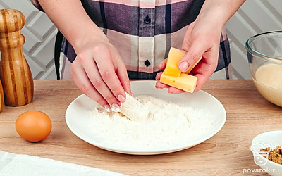 Нарежьте сыр на небольшие куски, обваляйте каждый кусок в муке.