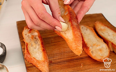 Натрите ломтики хлеба зубчиком чеснока.