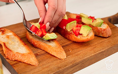 Соедините томаты, авокадо и лимонный сок, посолите, перемешайте и выложите смесь на ломтики багета.