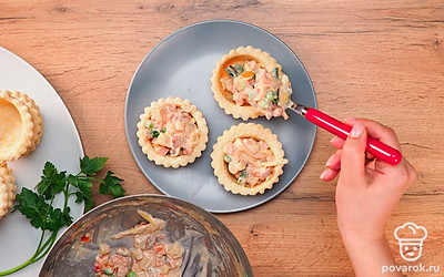 Обжаренные овощи высыпьте в миску и добавьте к ним тертый сыр, майонез, томатный соус, соль по вкусу. Все перемешайте и выложите в корзиночки из теста.