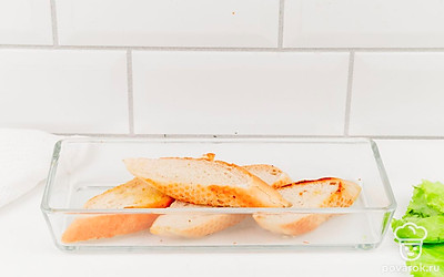 Хлеб нарежьте на ломтики. Выложите в форму для запекания. Отправьте в духовку подсушиться на 5 минут при 180⁰С.