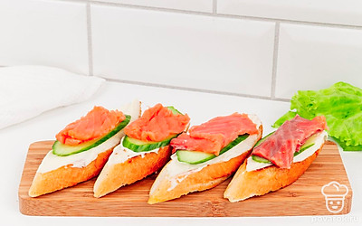 Выложите на сырный слой огурцы и лосось. Брускетты готовы.