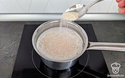 Накрыть крышкой и на большом огне нагреть, но до кипения не доводить. В этот момент снять крышку, убавить огонь до среднего и начать добавлять крупу по 1 столовой ложке. На 4 порции понадобится примерно 8 столовых ложек с горкой. Перемешивать манную кашу нужно каждые 30-60 секунд, чтобы она не пригорела и равномерно приготовилась. Каша варится примерно 12-15 минут.