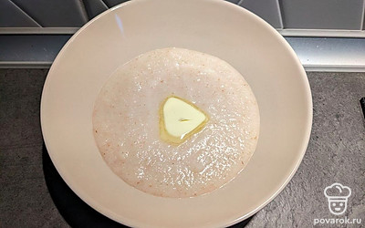 Разложить кашу по тарелкам, добавить кусочек сливочного масла и украсить кусочками манго.