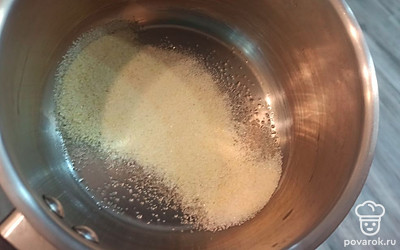 Манную крупу смешиваем с сахаром, заливаем водой и ставим на средний огонь. 