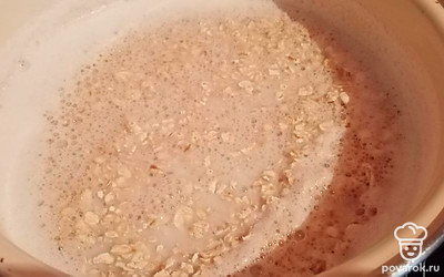 Когда молоко закипит, всыпать хлопья и сахар. Уменьшить огонь. Варить 7-10 минут. 