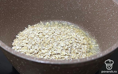 Добавьте овсянку в растопленное масло и перемешайте.