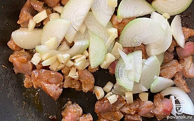 Лук и чеснок помойте, почистите и лук порежьте полукольцами, чеснок порежьте мелкими кусочками и добавьте к мясу.