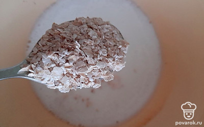 Перелейте молоко в кастрюлю и поставьте на огонь. Когда молоко закипит, убавьте газ, всыпьте овсяные хлопья и перемешайте.