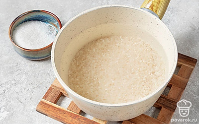 Добавьте сахар и всыпьте рис. Уменьшите огонь и варите примерно 10 минут, пока рис не увеличится в объеме.