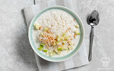 Выложите кашу в пиалу, сверху положите кусочки яблок и измельченный кешью.