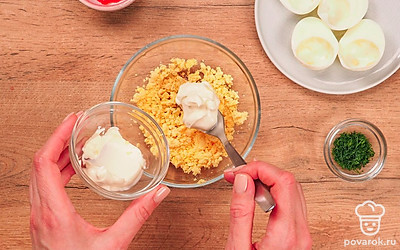 Подготовьте начинку. Разомните желтки, добавьте к ним майонез, перемешайте.