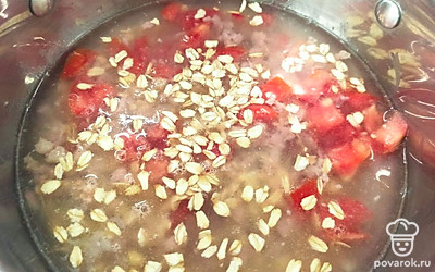 Помидор нарезаем. В кастрюлю выкладываем помидор и овсянку, все заливаем водой, солим. Варим 15 минут. 