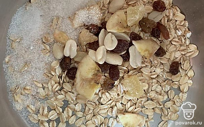 Смешать овсяные хлопья, сахар, цукаты, изюм и орехи. Залить молоком и довести до готовности.