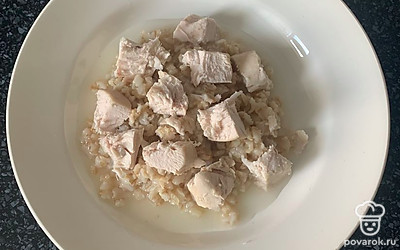 В кашу добавить сливочное масло и кусочки курицы. Перемешать.