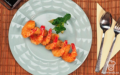 Подавайте креветки в сухарях с медово-соевым соусом и нарезанным лаймом.