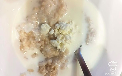 Влейте в кашу кефир и творог. Перемешайте.