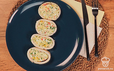 Готовые кальмары, фаршированные крабовыми палочками и сыром, разрежьте на кольца. Выложите на сервировочное блюдо.